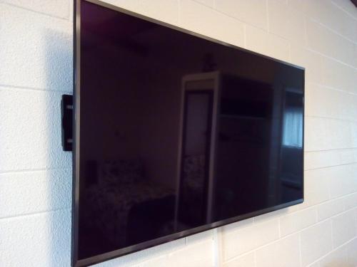 a flat screen tv hanging on a wall at Redwood Lodge Motel in Levin