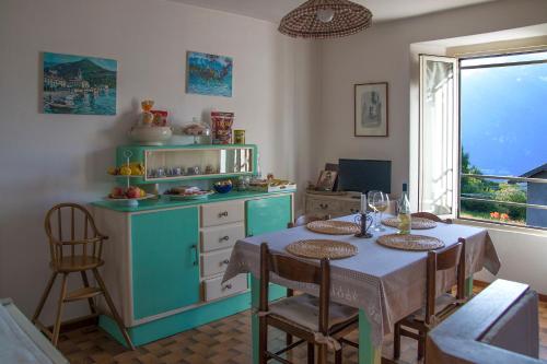 a kitchen with a table with chairs and a table and a kitchen with a counter at Holiday Home Liliana in Faggeto Lario 
