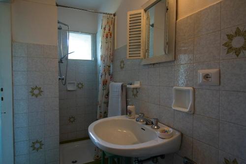 a bathroom with a sink and a mirror and a tub at Holiday Home Liliana in Faggeto Lario 