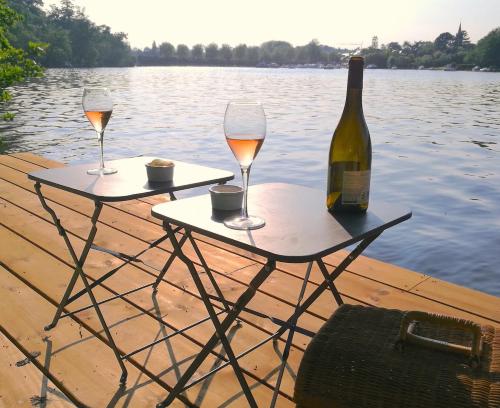 - deux tables avec des verres à vin et une bouteille de vin dans l'établissement Le Nid de l'Erdre, à Sucé-sur-Erdre