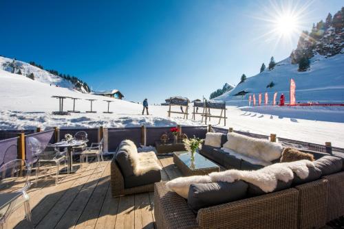 a living room with couches and a snow covered slope at Hotel du Lac in Villars-sur-Ollon