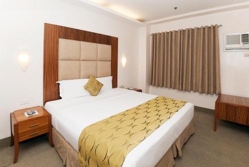 a bedroom with a large bed in a hotel room at City Garden Suites Manila in Manila