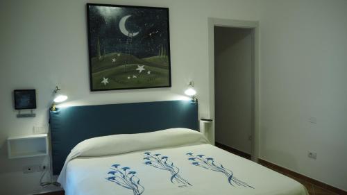 a bedroom with a bed with a painting on the wall at R&B Giardino 34 in Forlì