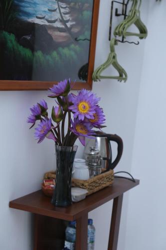 a vase filled with purple flowers on a table at Villa Gaetano Unawatuna in Unawatuna