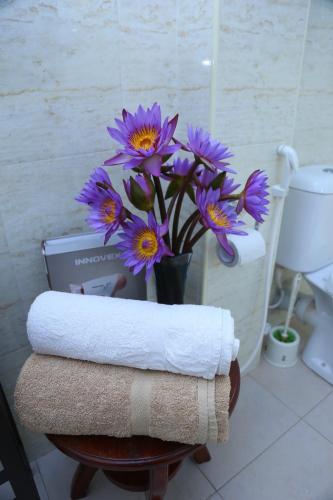 a vase of purple flowers on a table in a bathroom at Villa Gaetano Unawatuna in Unawatuna