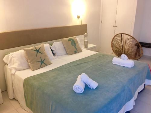 a bedroom with a large bed with towels on it at Hotel Miramar in Port de Soller