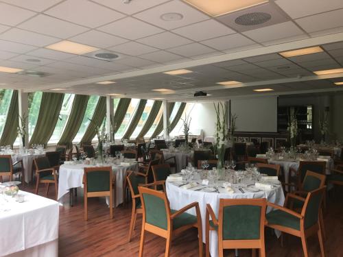 a dining room with tables and chairs with white tablecloths at Øren Hotel in Høyanger