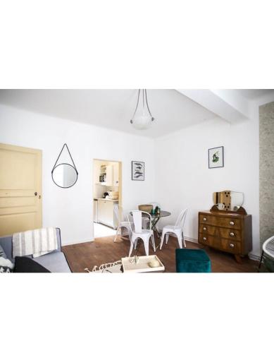 un salon avec un canapé, une table et des chaises dans l'établissement Appartement centre ville d'Arles, à Arles