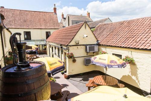 a view of a building with umbrellas and tables at The Swan in Thornbury