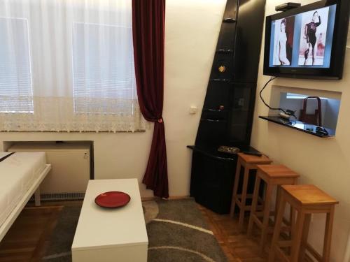 een kleine woonkamer met een tv en een tafel bij Lola 1 in Belgrado