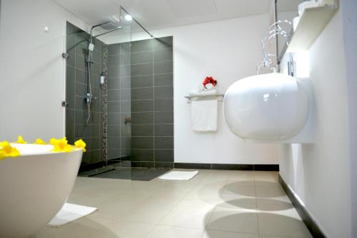 a bathroom with a shower and a toilet and a sink at Toparadis Guest House in Pereybere