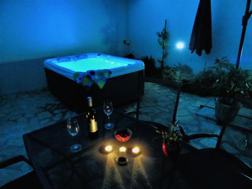 a room with a tub and a table with wine glasses at Apartman Nik in Nova Vas