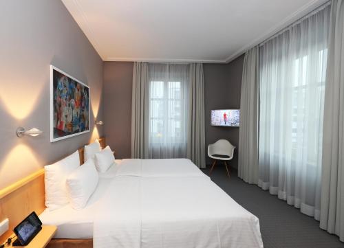 a hotel room with a white bed and a window at MOMA1890 Boutique Hotel in Munich