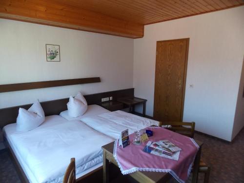 um quarto com duas camas e uma mesa e uma porta em Gasthof Rhönperle em Kothen