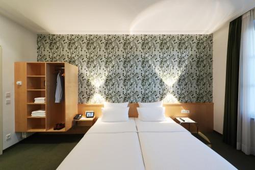 a bedroom with a large bed and a large window at MOMA1890 Boutique Hotel in Munich
