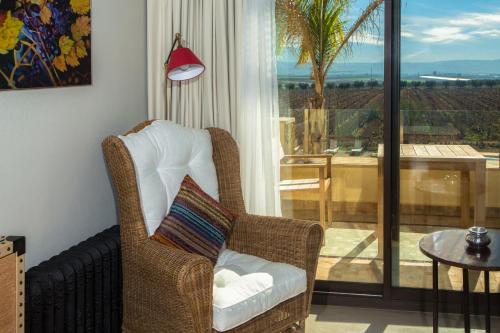 a wicker chair in a living room with a balcony at Château Roslane Boutique hôtel & Spa in Meknès