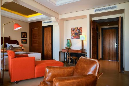 a bedroom with a bed and a couch and chairs at Château Roslane Boutique hôtel & Spa in Meknès