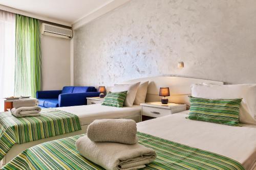 Habitación de hotel con 2 camas y sofá en Hotel Magnolija, en Budva
