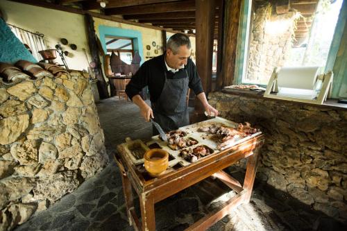 Un homme dans une cuisine préparant de la nourriture sur une table dans l'établissement Agriturismo Barbagia, à Alghero
