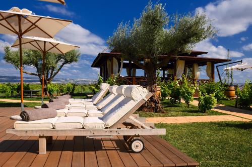 a row of white lounge chairs and umbrellas on a deck at Château Roslane Boutique hôtel & Spa in Meknès