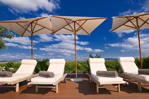a group of chairs and umbrellas on a deck at Château Roslane Boutique hôtel & Spa in Meknès