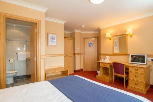 a hotel room with a bed and a bathroom at Station Hotel in Ellon