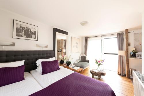 リエムストにあるB&B Montenakerhofのベッドルーム1室(大型ベッド1台、紫色の枕付)