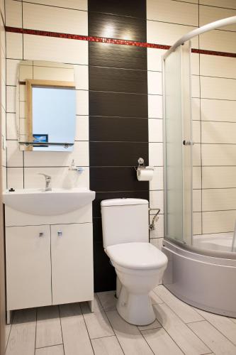 a bathroom with a white toilet and a sink at Sevilla Park in Międzywodzie