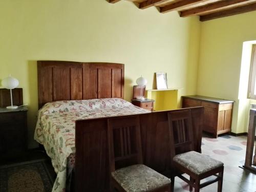 a bedroom with a bed and two chairs in it at Talonno il frutteto in Invorio Inferiore