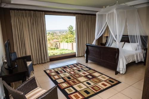 a bedroom with a bed and a large window at Royal Solwezi Hotel in Solwezi