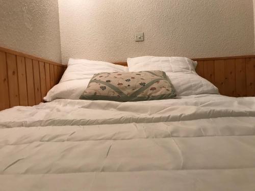 - un lit blanc avec un oreiller dans l'établissement Au pied du telecabine, T2 parking et casier a ski, à Cauterets