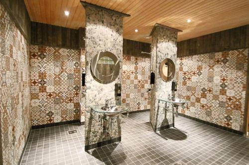 a bathroom with two sinks and two mirrors at Hotel Hullu Poro in Levi