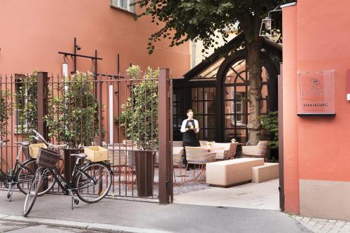 a woman is standing outside of a building at Hôtel Du Dragon in Strasbourg