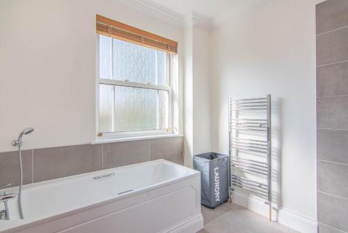 a white bath tub in a bathroom with a window at Jubilee Mansions 5* retreat in Peterborough