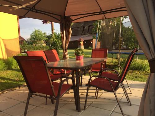 - une table et des chaises sous un parasol sur la terrasse dans l'établissement Hanga Apartments, à Sovata