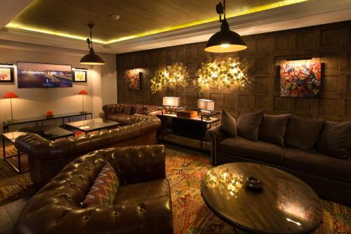 a living room with leather couches and a table at Château Roslane Boutique hôtel & Spa in Meknès