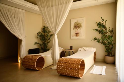 two beds in a room with curtains and plants at Château Roslane Boutique hôtel & Spa in Meknès
