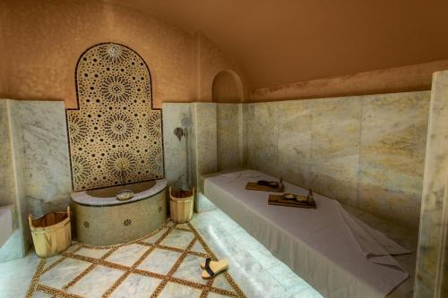 a bathroom with a tub and a shower in a room at Château Roslane Boutique hôtel & Spa in Meknès