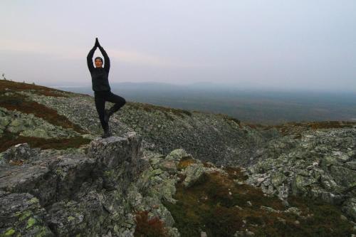 a man doing yoga on the side of a mountain at Hotel Hullu Poro in Levi