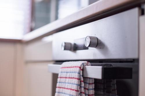 a towel hanging from the handle of an oven at Peebles House - Coorie Doon Apartments in Ayr