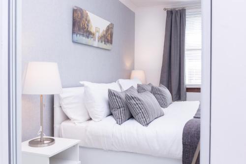 un soggiorno con divano bianco e cuscini di Peebles House - Coorie Doon Apartments ad Ayr