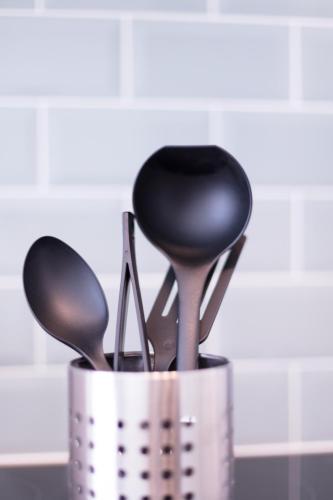 a metal container filled with utensils on a counter at Peebles House - Coorie Doon Apartments in Ayr