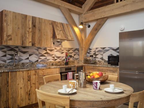 uma cozinha com uma mesa de madeira e uma taça de fruta em Macdui Lodge em Aviemore