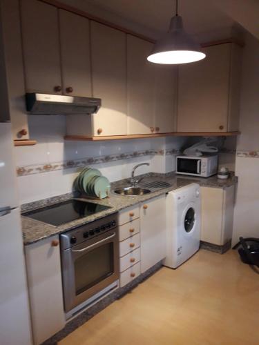 uma cozinha com um lavatório e um fogão forno superior em Apartamento Sobradelo em Vilagarcía de Arousa