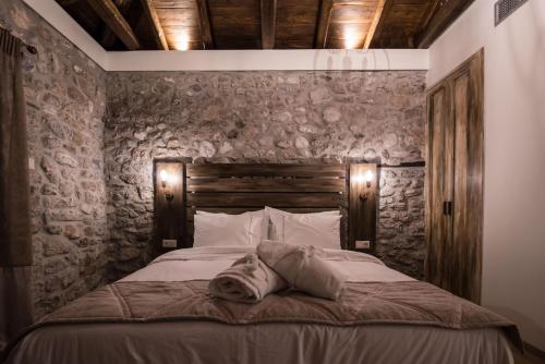 a bed in a room with a stone wall at Mythic Valley in Litochoro
