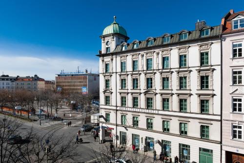 a large white building with a clock tower at MOMA1890 Boutique Hotel in Munich