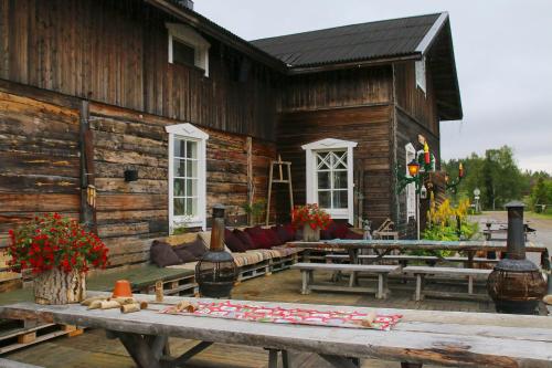 a wooden cabin with tables and couches in front of it at Elves Village Hotel in Levi