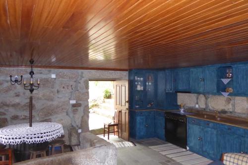 a kitchen with blue walls and a wooden ceiling at Casa do Rio in Moita