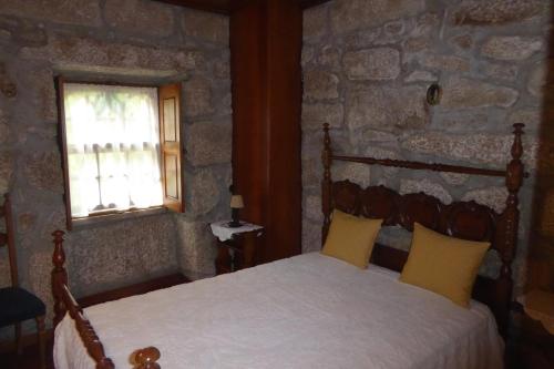 a bedroom with a bed in a stone wall at Casa do Rio in Moita