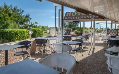 a row of tables and chairs at a restaurant at Hotel Les Dunes in Marseillan
